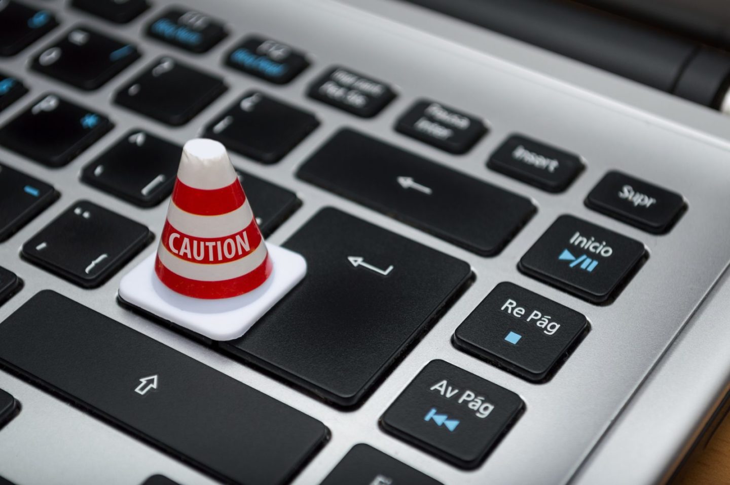 Image of a computer keyboard with small caution cone on the return button